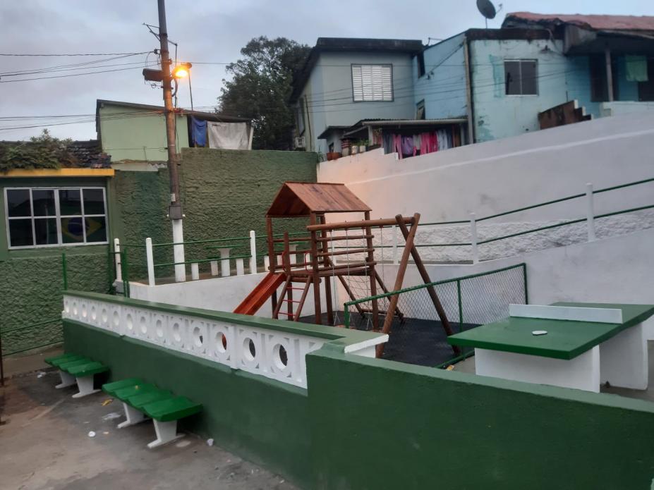 parque com brinquedos e mesa de pingue pongue cercado por mureta #paratodosverem