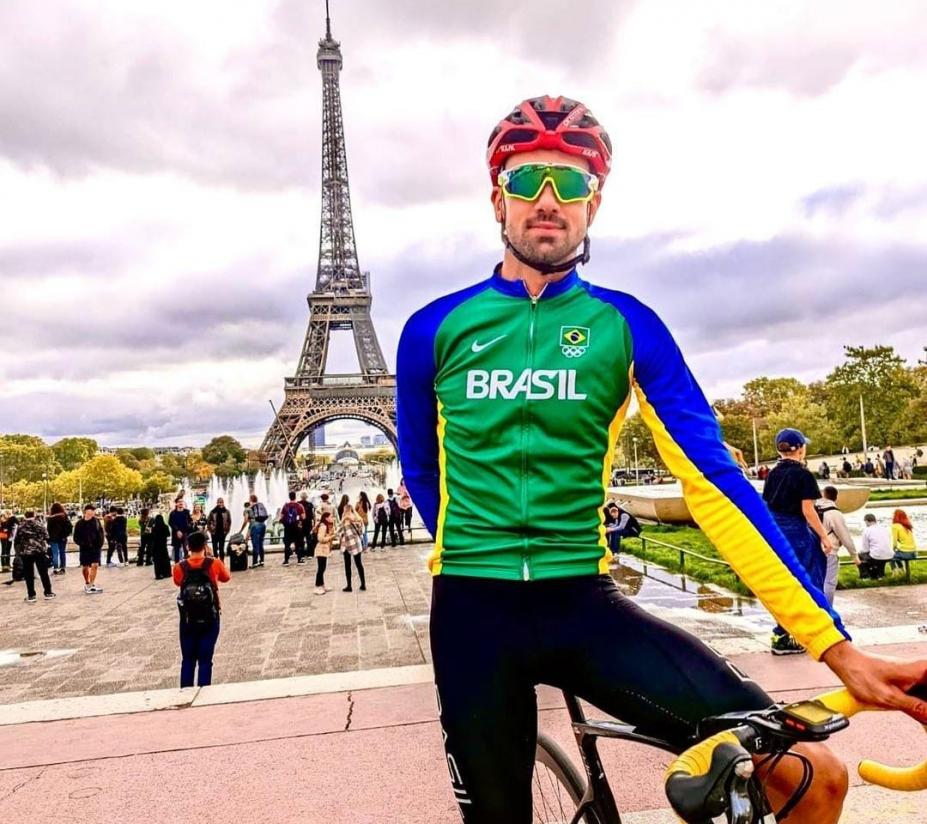 atleta em cima da bicicleta com torre eifel ao fundo #paratodosverem