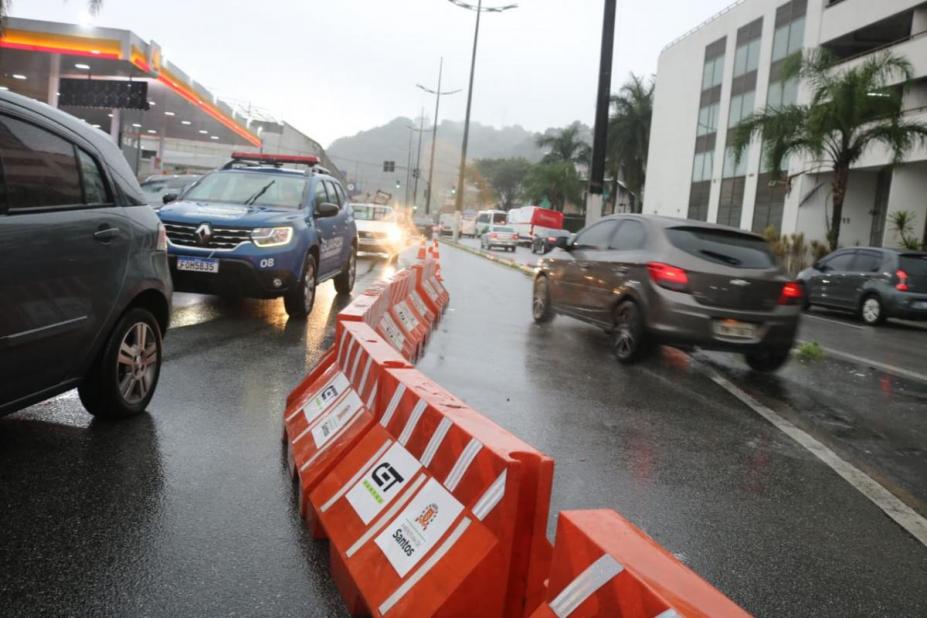 carros circulando por rua separados por defensas de plástico. #paratodosverem