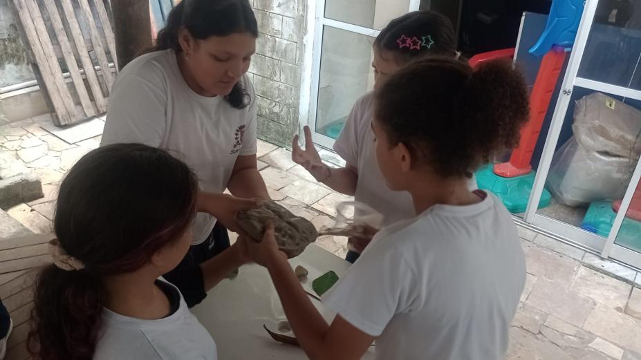 alunos participando da atividade com objetos indígenas nas mãos #paratodosverem