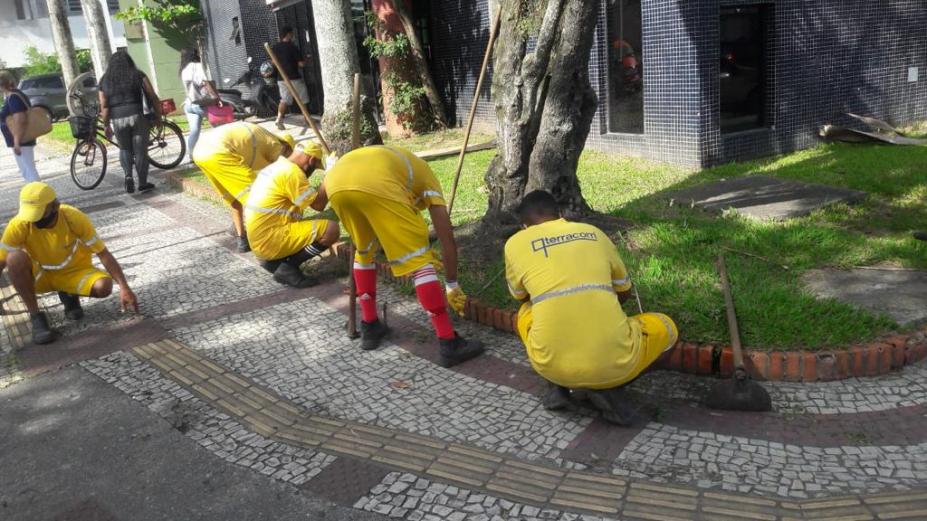 Trabalhadores fazem manutenção em jardim de calçada #paratodosverem