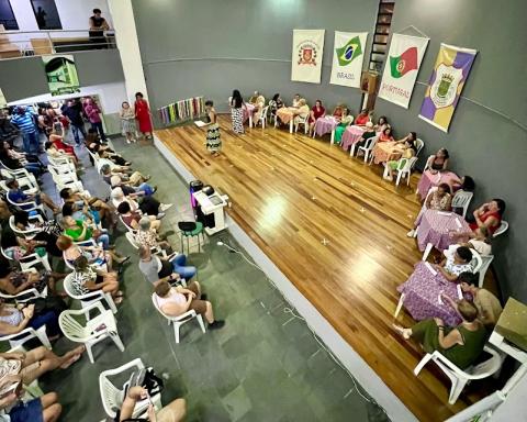 pessoas em um palco sentadas de frente para o público #paratodosverem