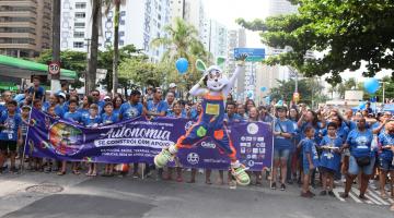 personagem do coelho salta na frente de multidão em caminhada. #paratodosverem
