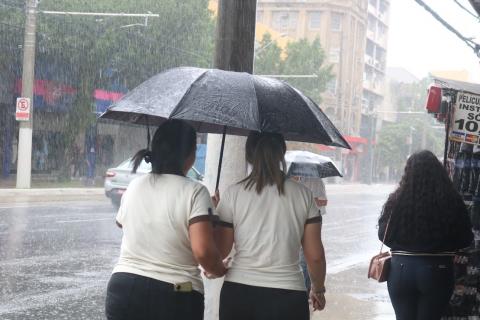 pessoas de guarda chuva na rua #paratodosverem