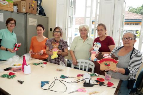 mulheres mostram enfeites de natal #paratodosverem