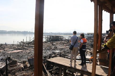 pessoas olham área atingida pelo incêndio #paratodosverem