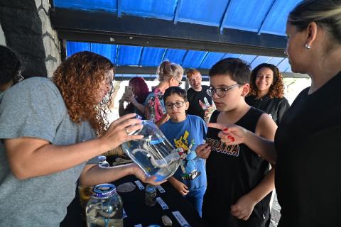 monitora mostra vidro com animal para aluno #paratodosverem 