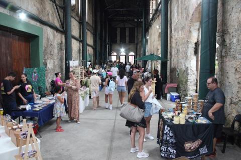 pessoas olhando produtos em feira #paratodosverem
