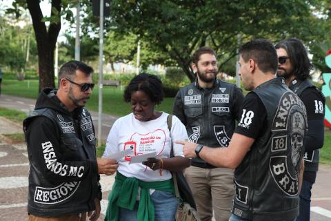 mulher distribui panfletos na rua #paratodosverem