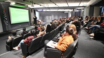 palestra com uma mulher falando para várias outras. #paratodosverem