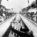 imagem de 1907 de inauguração de canal, com pessoas em embarcações dentro do canal, e fora, assistindo. #paratodosverem 