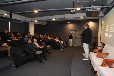 Pessoas no auditório acompanhando o evento #paratodosverem 