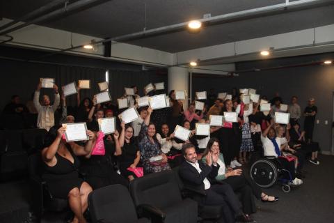 pessoas sentadas levantando diploma #paratodosverem