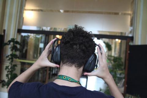 menino de costas coloca abafador nos ouvidos. #paratodosverem