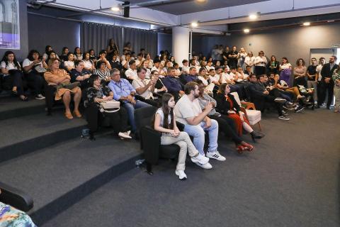 pessoas sentadas na platéia #paratodosverem