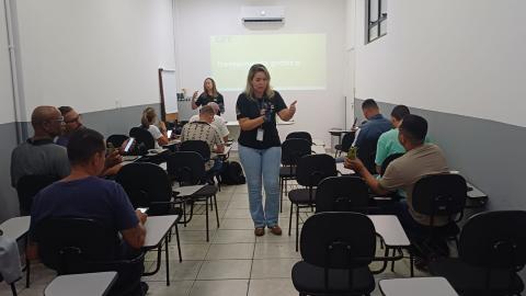aula de trânsito com alunos sentados e instrutora em pé. #paratodosverem