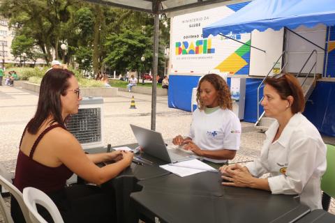 mulher sendo atendida em mesa na frente da carreta #paratodosverem