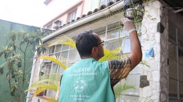 agente olha vaso em residência #paratodosverem