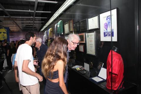 pessoas olhando exposição no museu pelé #paratodosverem 