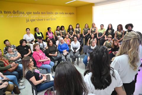 mulheres reunidas em salão assistem palestra. #paratodosverem