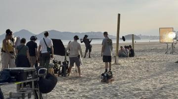 pessoas gravando filme em praia #paratodosverem 