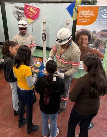crianças ao lado de técnico na aula #paratodosverem 