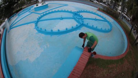 homem trabalhando em um fonte esvaziada. #paratodosverem