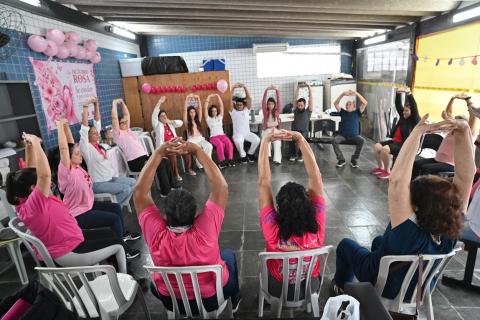 mulheres fazem alongamento sob tenda. #paratodosverem