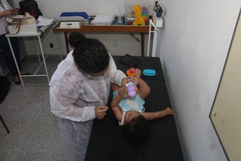 bebê é examinado em maca por mulher. #paratodosverem 