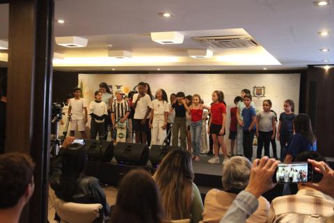 alunos em apresentação sobre um palco. #paratodosverem