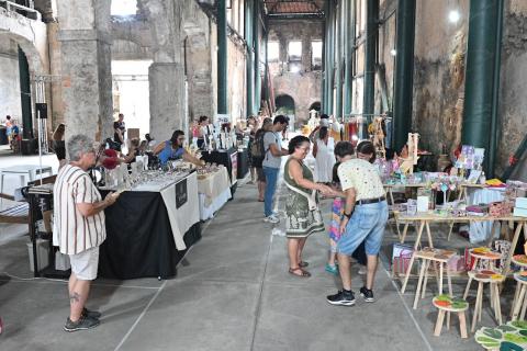 pessoas olhando produtos em feira #paratodosverem
