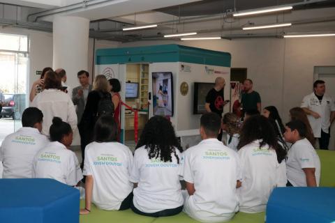 estudantes sentados na frente da estação #paratodosverem