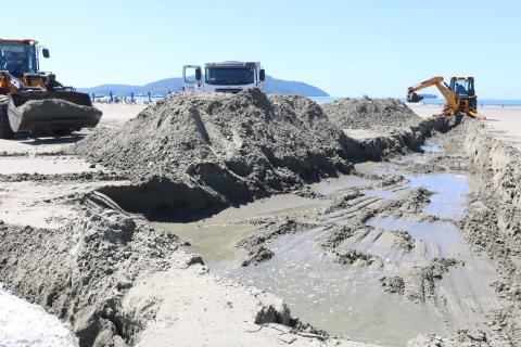 máquina retira areia de canal na praia. #paratodosverem