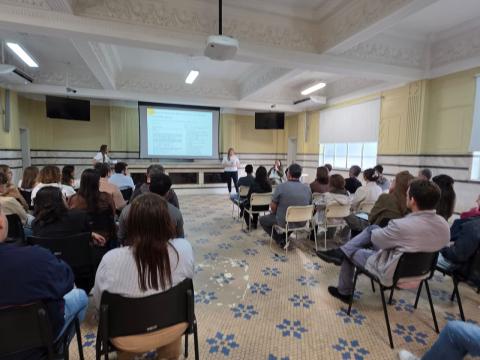 pessoas sentada e um telão ao fundo #paratodosverem