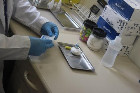 mãos com luvas mexem em medicamentos. #paratodosverem