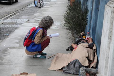 Projeto contemplará a formação das equipes, construção da metodologia, escuta de pessoas em situação de rua, mapeamento dos pontos de pernoite e outras informações. Fotos: arquivo operadora se aproxima de pessoa deitada na rua #paratodosverem