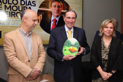 Ministro foi condecorado pela Associação Comercial de Santos e pela Associação Paulista de Magistrados - fotos: Marcelo Martins homem segura placa. ele está no meio de duas pessoas. #paratodosverem