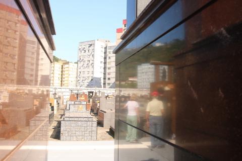 Além da programação religiosa, necrópoles oferecem música e atendimento ao público ao longo dos dois dias - fotos: Raimundo Rosa reflexo de visitantes em túmulo de cemitério. #paratodosverem