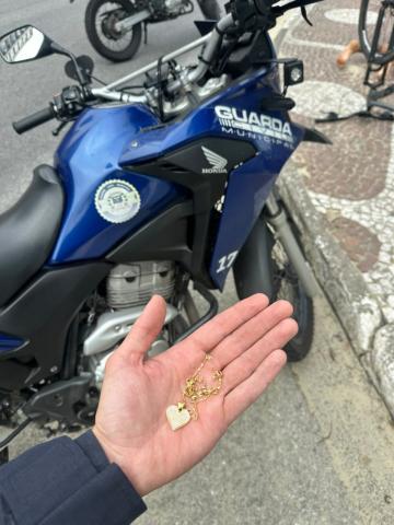 Objeto foi recuperado pelos agentes e devolvido à vítima. Foto: divulgação mão mostra correntinha #paratodosverem