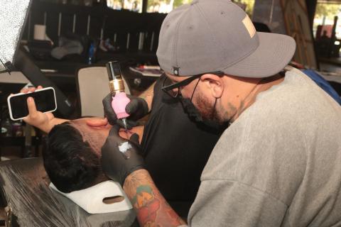 Evento segue neste domingo, no Centro de Cultura Patrícia Galvão, das 14g às 22h - fotos: Raimundo Rosa tatuador cria imagem em um homem que está deitado. #paratodosverem