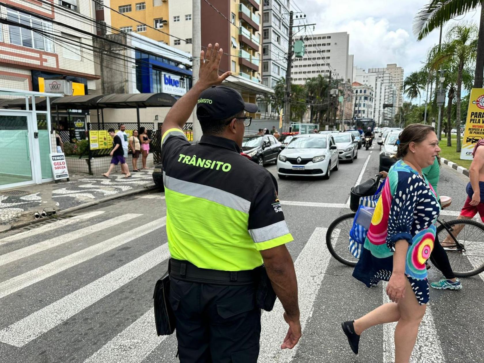 agente ajuda pedestres a atravessar rua #paratodosverem
