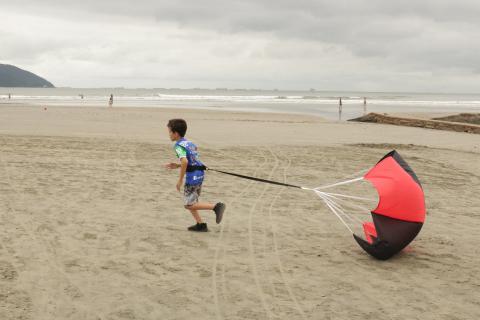 menino corre com paraquedas #paratodosverem