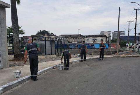 operários realizando pintura em guias #paratodosverem 