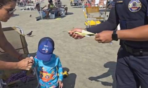 guarda coloca pulseira em criança #paratodosverem