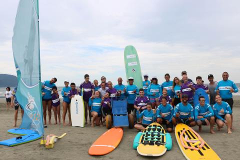 grupo de surfistas posa com pranchas na praia #pracegover