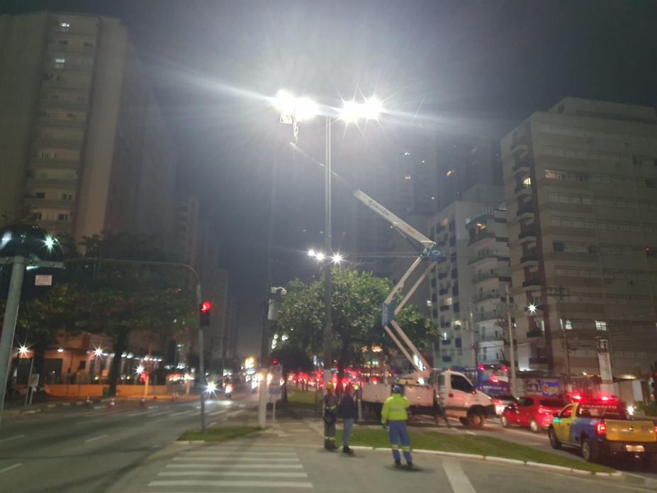 caminh&atilde;o com cesto parado ao lado de poste iluminado. #paratodosverem 